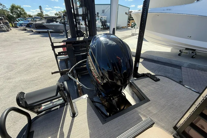 Slide: The Image of 2025 Bennington 23 LPD boat with a powerful outboard motor in a marina setting. - 9