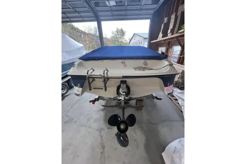 Slide: The Image of 1997 Regal Valanti 200 boat in storage, rear view with blue cover. - 28