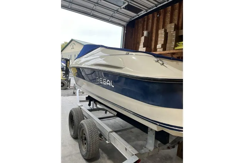 Slide: The Image of 1997 Regal Valanti 200 boat interior with blue carpet and beige seating. - 5