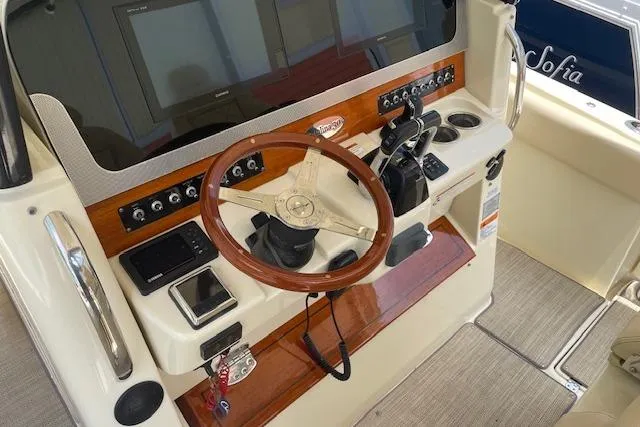 Slide: The Image of 2020 Chris-Craft Catalina 30 helm with wooden steering wheel and modern controls. - 23