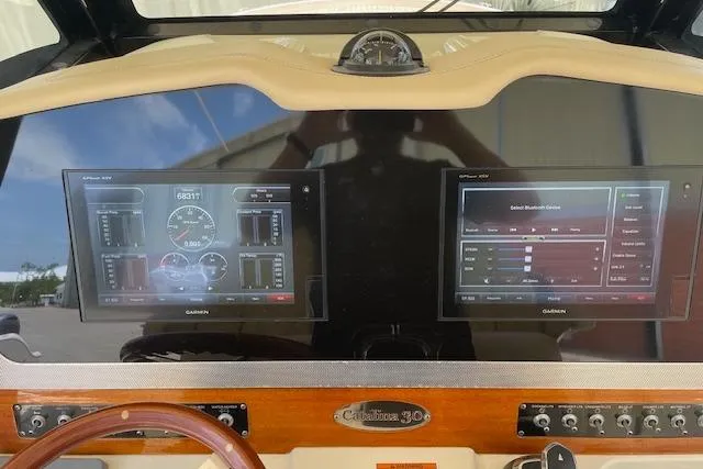 Slide: The Image of 2020 Chris-Craft Catalina 30 dashboard with dual Garmin displays and wooden accents. - 24