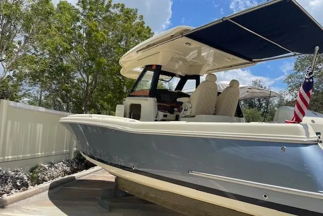 Slide: The Image of 2020 Chris-Craft Catalina 30 boat with canopy, docked outdoors under a blue sky. - 4