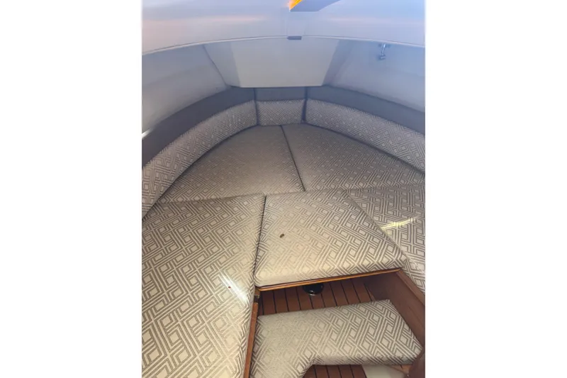 Slide: The Image of 2021 Ranger Tugs R-25 cabin interior with patterned cushions and wooden flooring. - 19