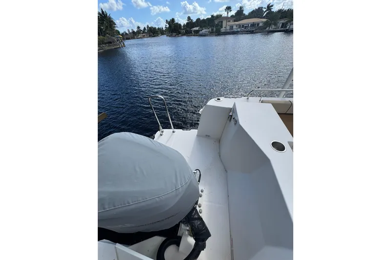 Slide: The Image of 2021 Ranger Tugs R-25 boat on a serene waterfront with clear skies. - 5