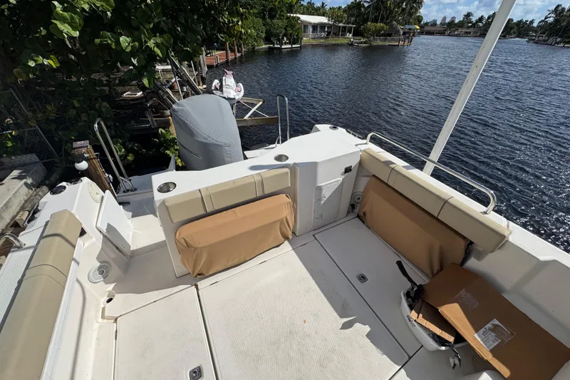 Slide: The Image of 2021 Ranger Tugs R-25 boat deck with seating, overlooking a serene waterfront. - 7