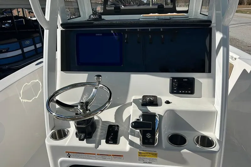 Slide: The Image of 2026 Sea Pro 245FLX Sandbar boat dashboard with steering wheel and controls. - 12