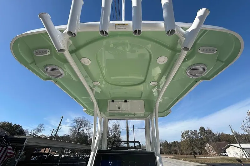 Slide: The Image of 2026 Sea Pro 245FLX Sandbar boat with green canopy and rod holders, viewed from below. - 14