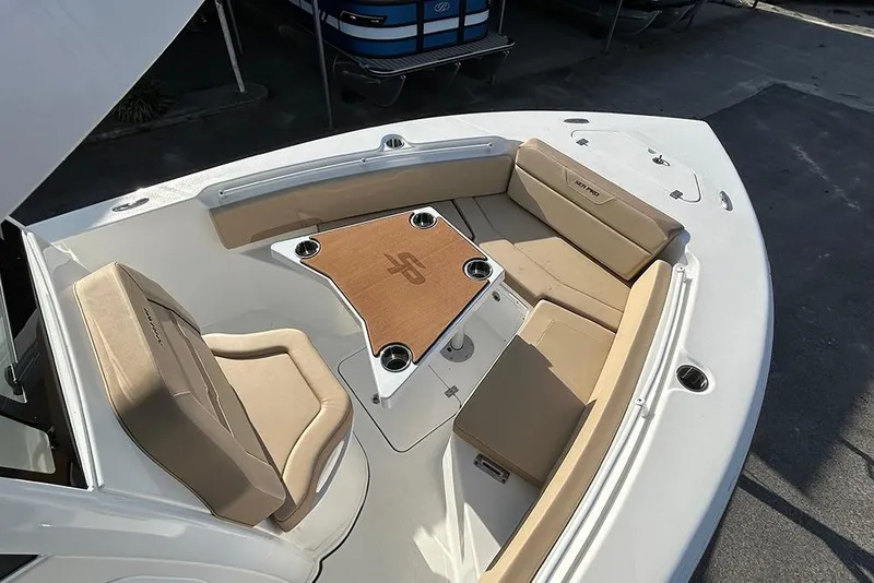 Slide: The Image of 2026 Sea Pro 245FLX Sandbar boat interior with beige seating and central table. - 30