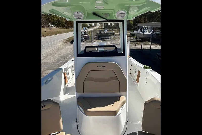 Slide: The Image of 2026 Sea Pro 245FLX Sandbar boat interior with beige seating and green canopy. - 53