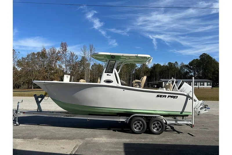 Slide: The Image of 2026 Sea Pro 245FLX Sandbar boat on trailer, parked outdoors under clear blue sky. - 9