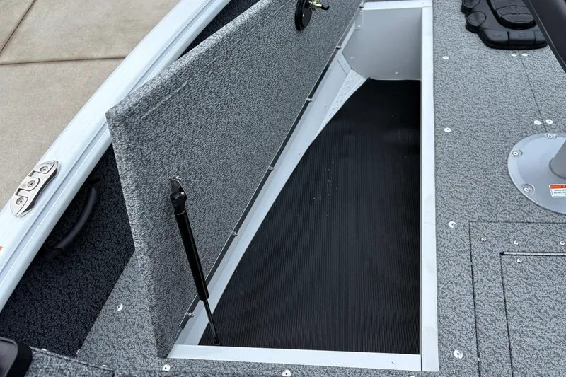 Slide: The Image of 2026 Lund 1800 Explorer Sport boat storage compartment with open lid, showcasing interior space. - 11