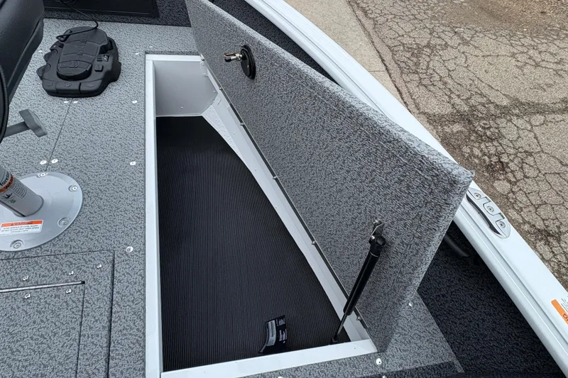 Slide: The Image of 2026 Lund 1800 Explorer Sport boat with open storage compartment on deck. - 12