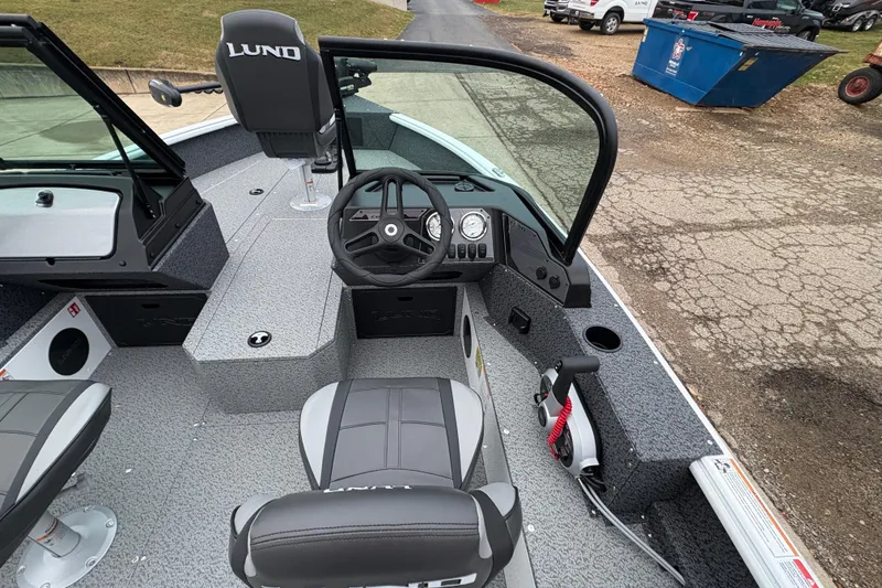 Slide: The Image of 2026 Lund 1800 Explorer Sport boat interior with steering wheel and seating. - 17