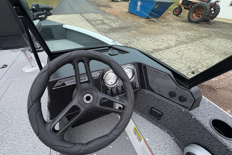 Slide: The Image of 2026 Lund 1800 Explorer Sport boat dashboard with steering wheel and gauges. - 18