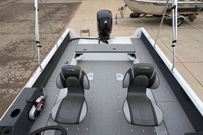Slide: The Image of 2026 Lund 1800 Explorer Sport boat interior with dual seats and motor. - 21