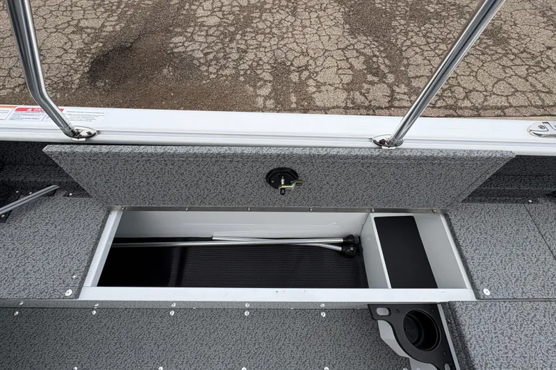 Slide: The Image of 2026 Lund 1800 Explorer Sport boat storage compartment with open hatch and visible interior. - 23