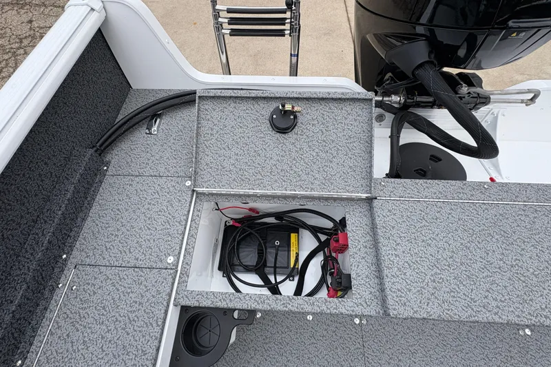 Slide: The Image of 2026 Lund 1800 Explorer Sport boat interior with storage compartment and motor. - 25
