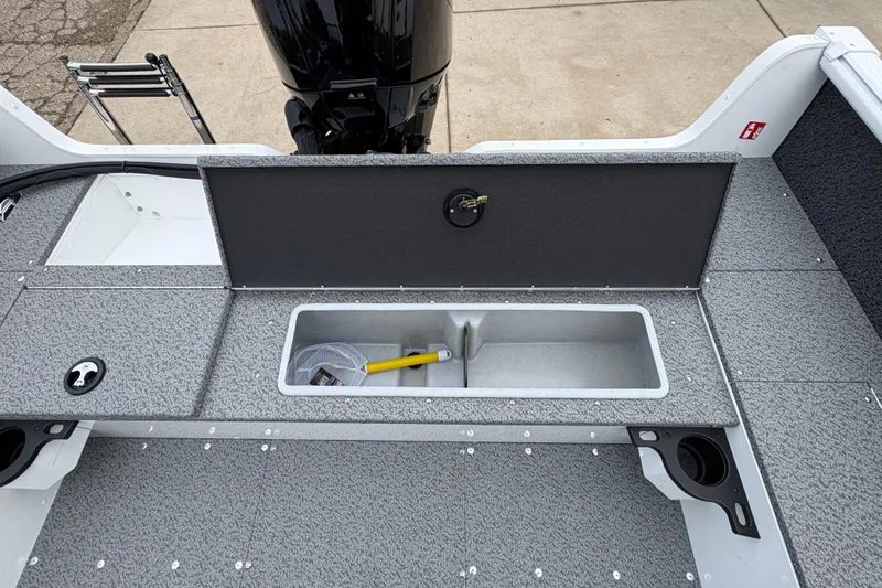 Slide: The Image of 2026 Lund 1800 Explorer Sport boat interior with storage compartment and motor. - 26