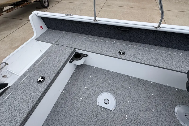 Slide: The Image of 2026 Lund 1800 Explorer Sport boat interior with gray seating and storage compartments. - 27