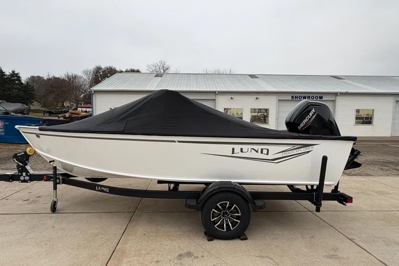 Slide: The Image of 2026 Lund 1800 Explorer Sport boat with cover on trailer, parked outside showroom. - 33