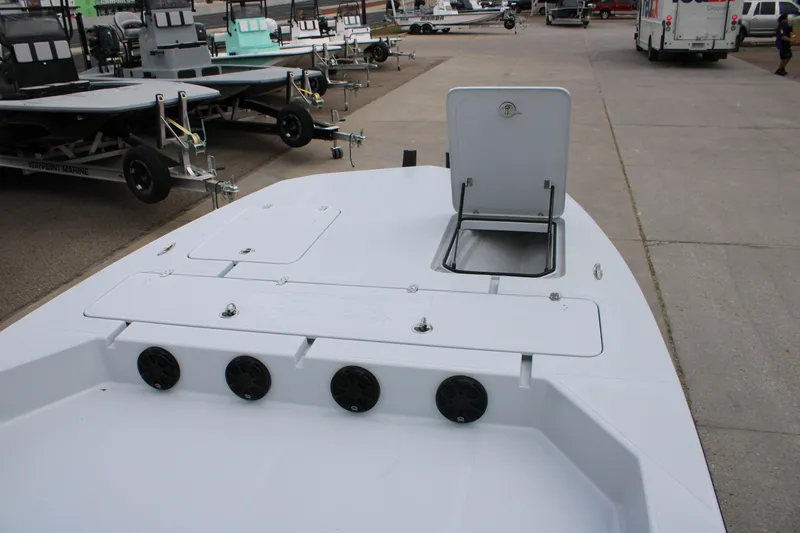 Slide: The Image of 2026 Mamba 24 Cat Elite boat deck with open hatch, parked among trailers. - 6