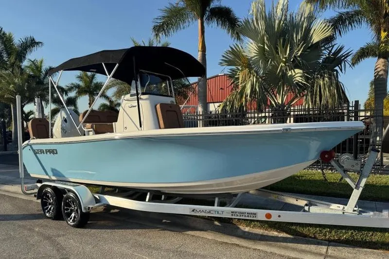 The Image of 2024 Sea Pro 202 Center Console boat on trailer, parked near palm trees. - 0