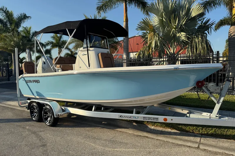 The Image of 2024 Sea Pro 202 Center Console boat on trailer, parked near palm trees. - 1