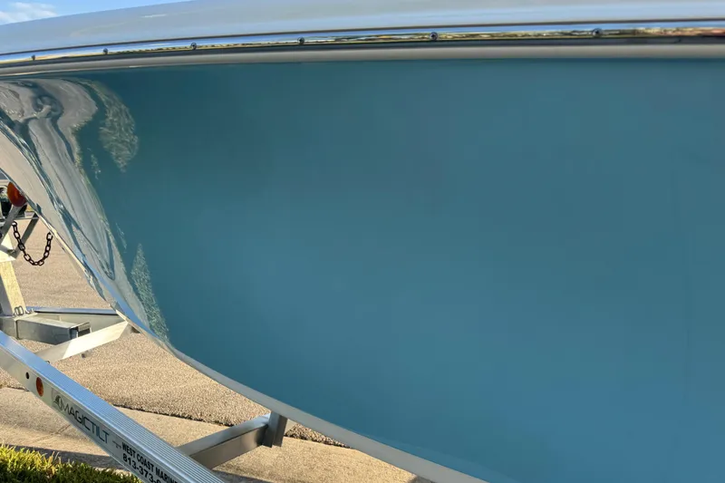 Slide: The Image of 2024 Sea Pro 202 Center Console boat on trailer, featuring sleek design and blue hull. - 32