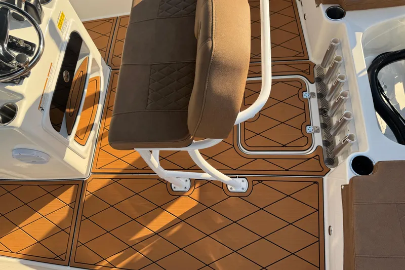 Slide: The Image of 2024 Sea Pro 202 Center Console boat interior with brown cushioned seating and teak-style flooring. - 54
