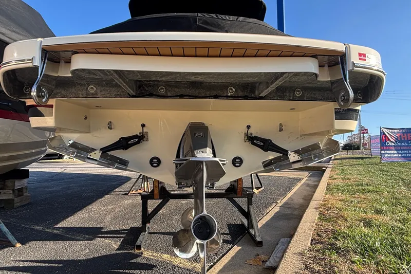 Slide: The Image of 2026 Chris-Craft Sportster 28 boat, rear view, parked outdoors on a sunny day. - 8
