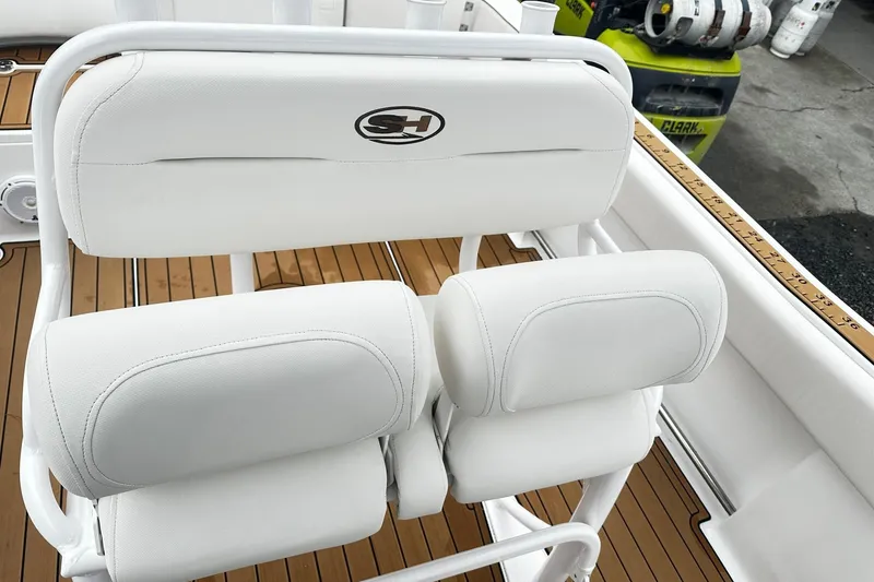 Slide: The Image of 2022 Sea Hunt Ultra 234 boat seating with white upholstery and teak flooring. - 10