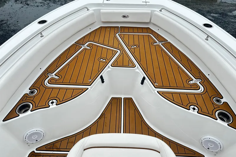 Slide: The Image of 2022 Sea Hunt Ultra 234 boat deck with teak-style flooring and storage compartments. - 11