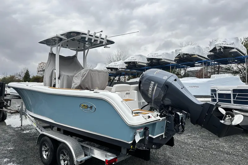 Slide: The Image of 2022 Sea Hunt Ultra 234 boat with Yamaha engine on trailer, overcast sky. - 2