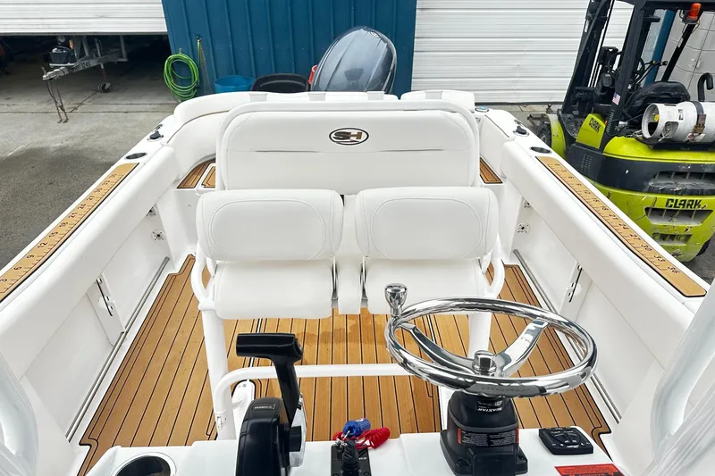 Slide: The Image of 2022 Sea Hunt Ultra 234 boat interior with white seating and wooden deck. - 9