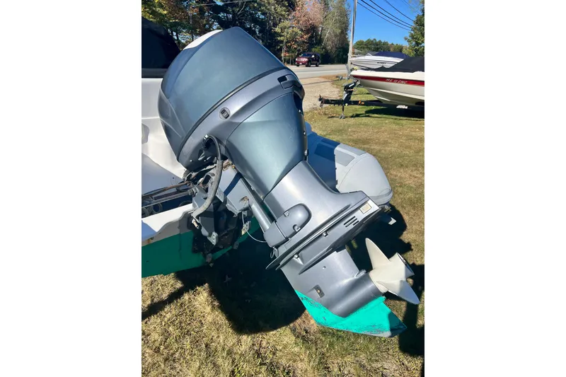 Slide: The Image of Outboard motor on a 2007 Caribe 16 boat, parked on grass. - 17