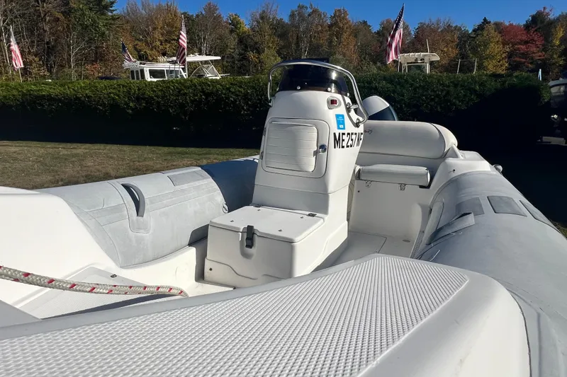 Slide: The Image of 2007 Caribe 16 inflatable boat with console, parked outdoors, surrounded by trees and flags. - 6