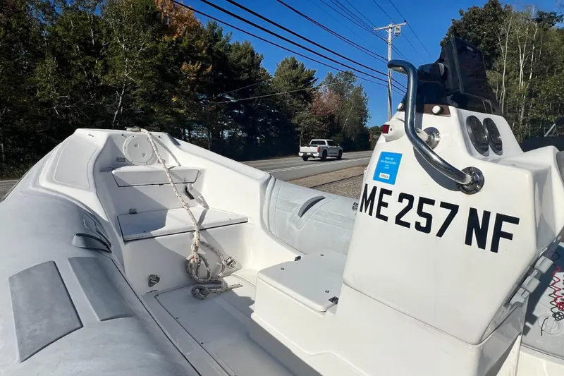 Slide: The Image of 2007 Caribe 16 boat with registration ME 257 NF, parked roadside under clear sky. - 8