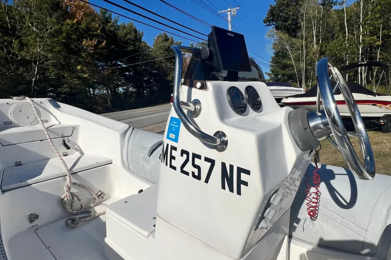 Slide: The Image of 2007 Caribe 16 boat with steering wheel and control panel, parked near trees. - 9