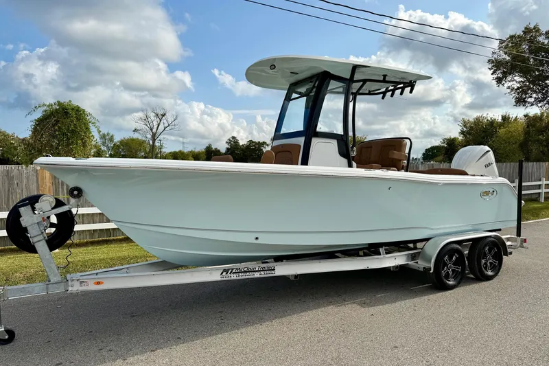 The Image of 2026 Sea Hunt Ultra 235 SE boat on trailer, parked outdoors under a cloudy sky. - 1