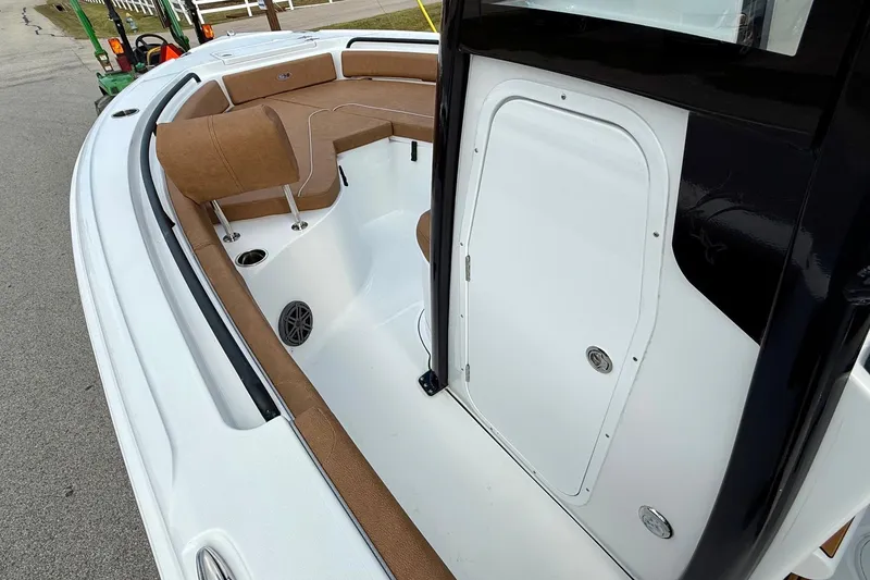 Slide: The Image of 2026 Sea Hunt Ultra 235 SE boat interior with brown seating and storage compartment. - 12