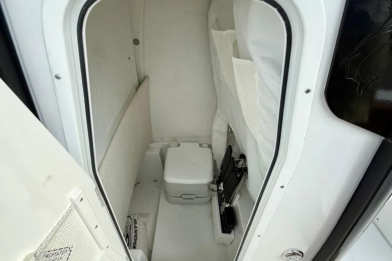 Slide: The Image of Interior of 2026 Sea Hunt Ultra 235 SE boat, featuring compact marine toilet. - 13