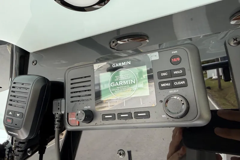 Slide: The Image of Garmin marine radio on 2026 Sea Hunt Ultra 235 SE boat dashboard. - 19
