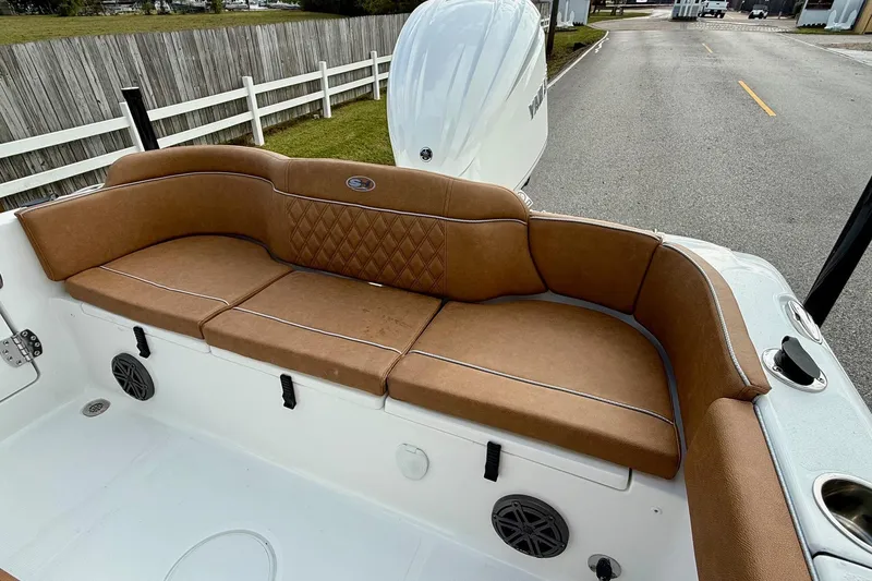 Slide: The Image of 2026 Sea Hunt Ultra 235 SE boat with brown cushioned seating and white interior. - 7