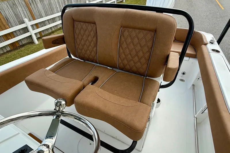 Slide: The Image of 2026 Sea Hunt Ultra 235 SE boat with brown cushioned seating and steering wheel. - 9