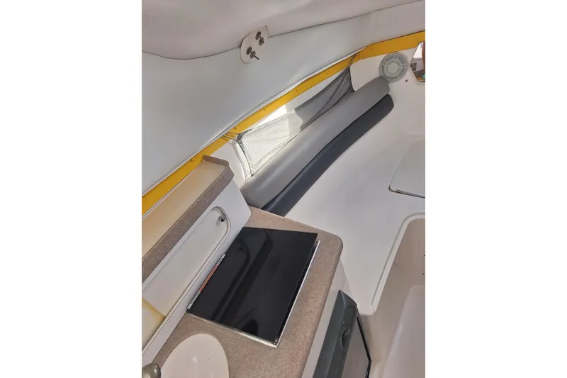 Slide: The Image of 2006 Century 2400 Walkaround boat interior with seating and fishing rod holders under a blue sky. - 10