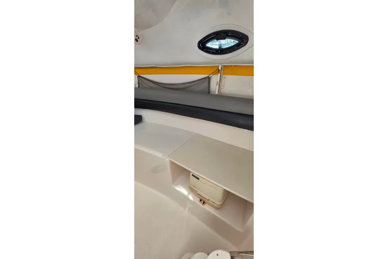 Slide: The Image of Interior of a 2006 Century 2400 Walk-Around boat, featuring seating and storage. - 17