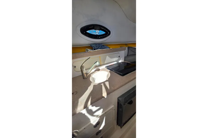 Slide: The Image of 2006 Century 2400 Walk-Around boat interior with sink and window. - 18