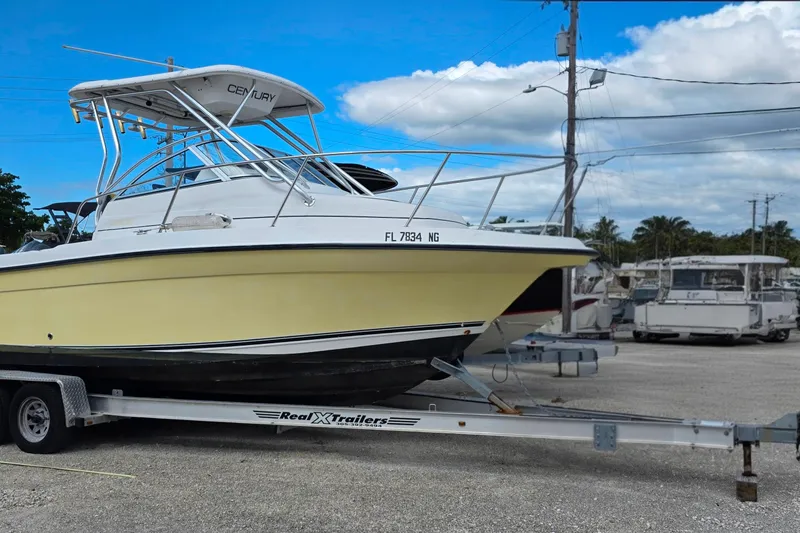 Slide: The Image of 2006 Century 2400 Walkaround boat on trailer, parked outdoors under blue sky. - 2