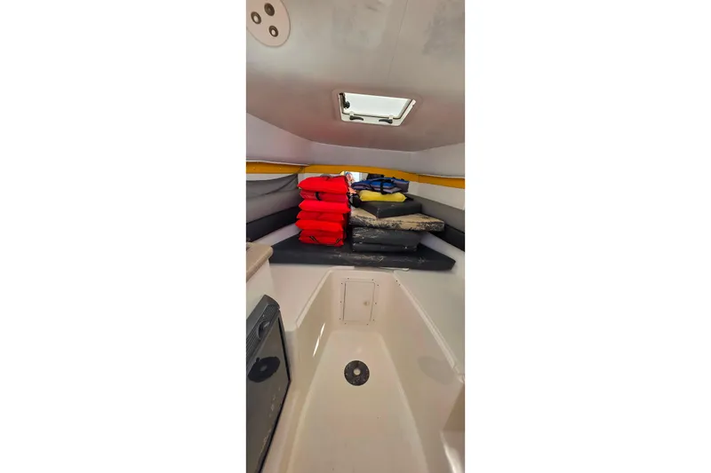 Slide: The Image of Interior of 2006 Century 2400 Walk-Around boat with life jackets and cushions. - 20