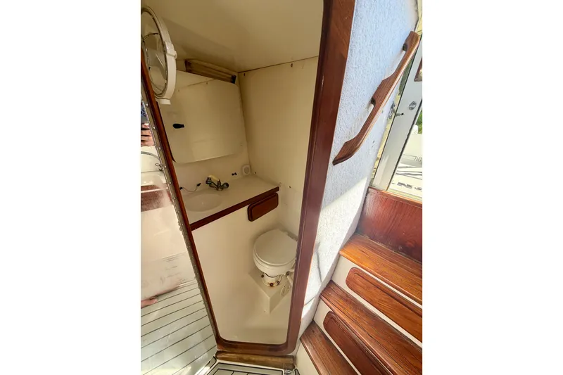 Slide: The Image of 2002 Contender 35 Side Console boat deck with railing, surrounded by lush greenery. - 12